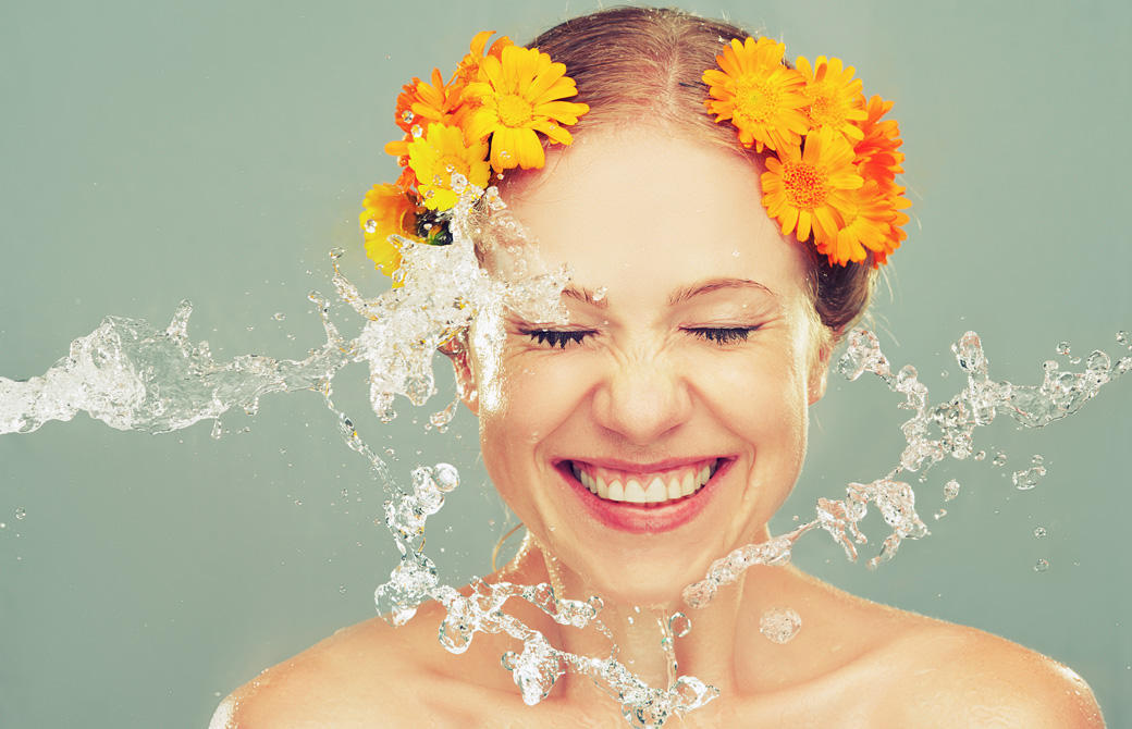 水しぶきを浴びて微笑む花輪を頭につけた女性