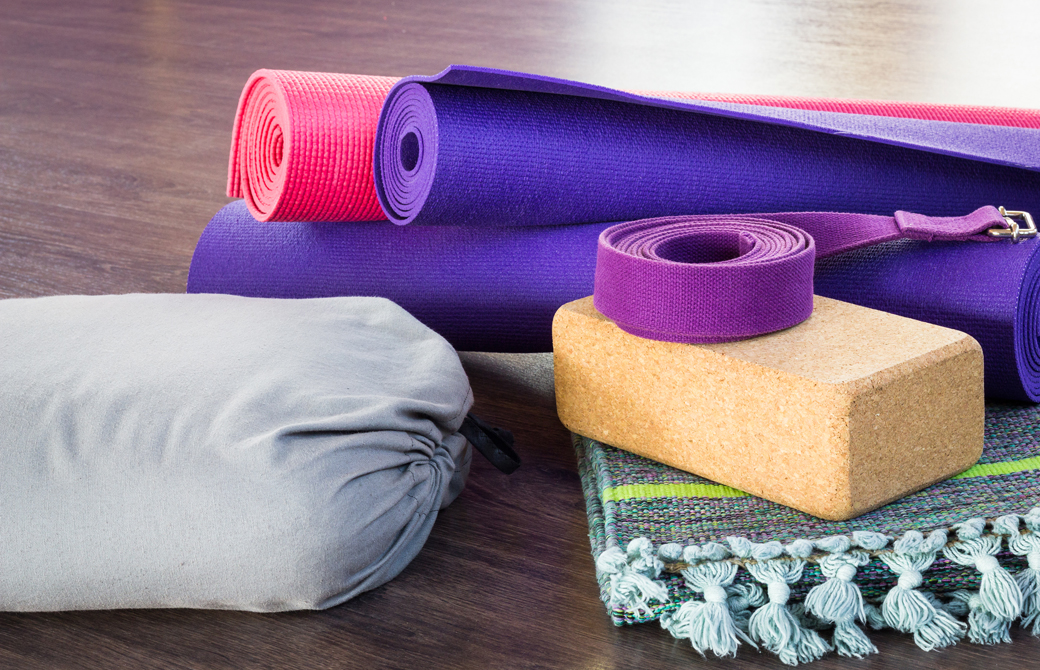 ボルスターやヨガベルト、ブロックなどのプロップスが重ねられている