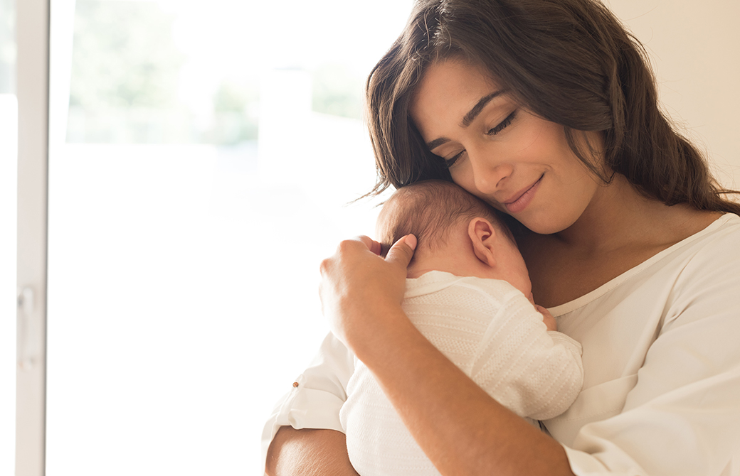 赤ちゃんを抱きしめている女性の微笑み