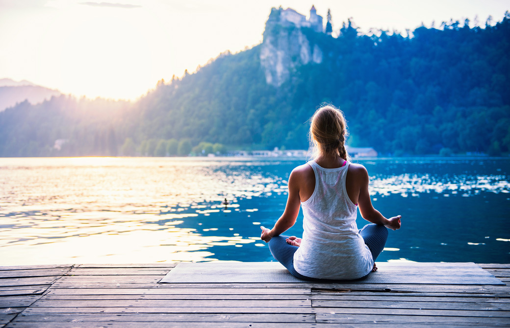湖のほとりで瞑想をする女性