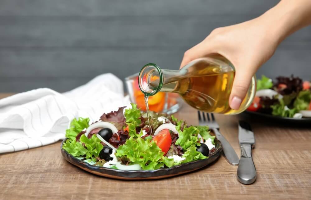 サラダに酢をかけている人の手