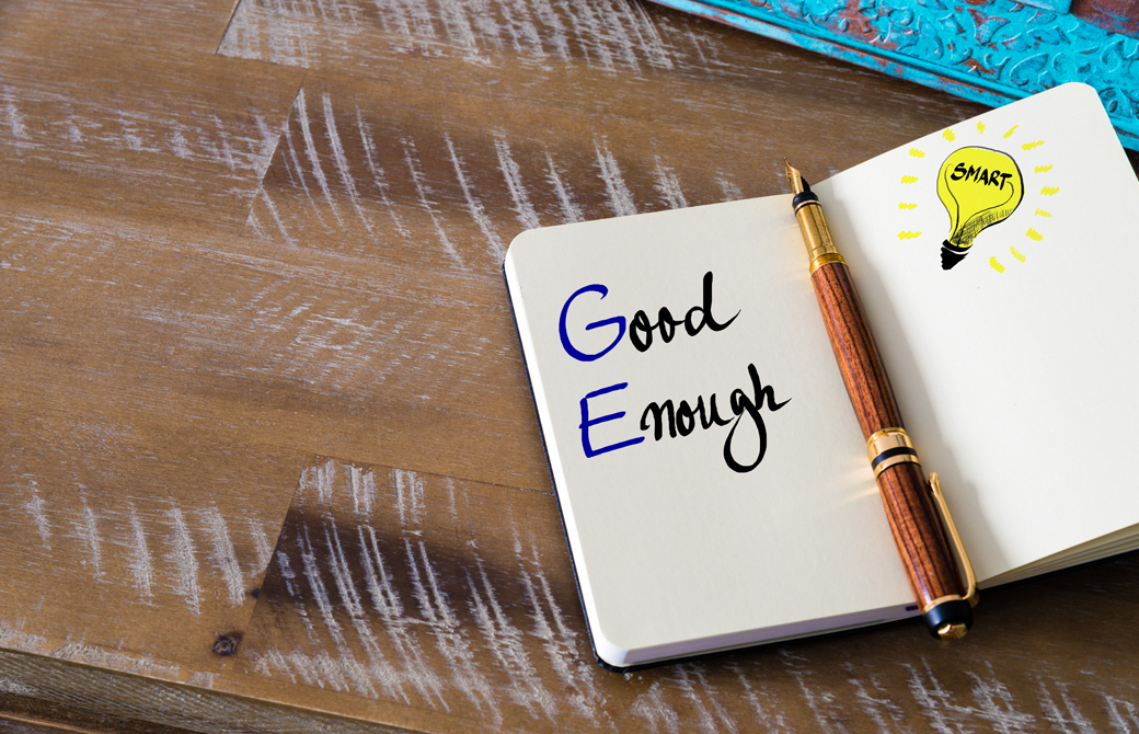 テーブルの上の手帳に書かれている「Good Enough」という文字