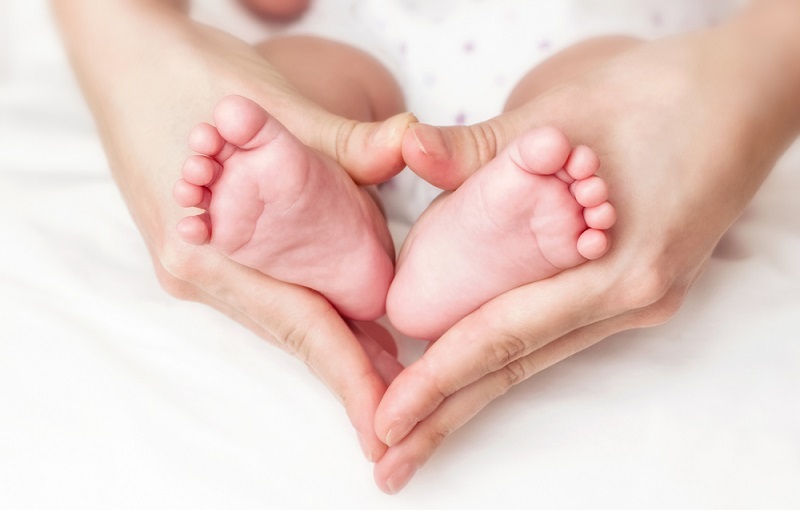 赤ちゃんの足とママの手