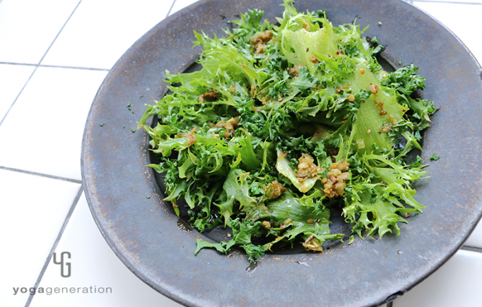 黒い皿に盛り付けたグリーンオリーブとアンチョビのガーリックオイル・サラダ