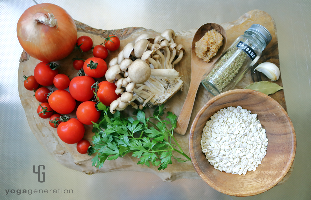 木製カットボードの上のトマトや押し麦などの材料