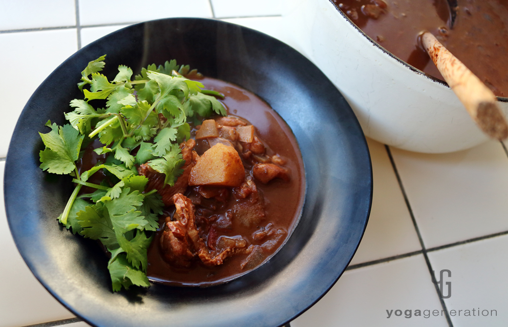 黒い器に盛りつけたジャガイモと鶏肉でメキシカン・スパイシー・チョコ・スープ