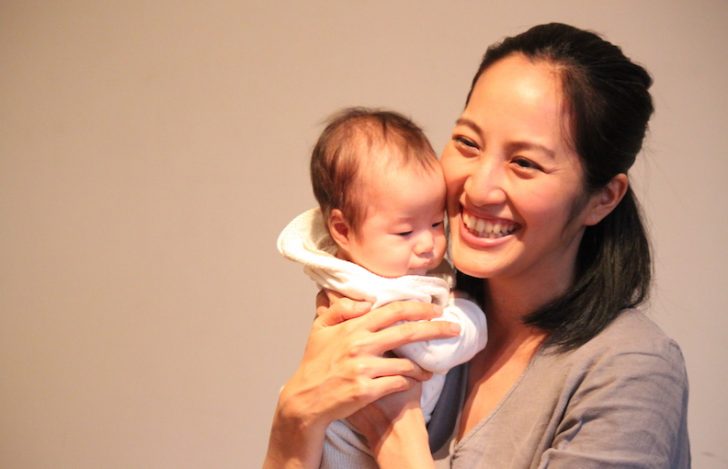 赤ちゃんを抱っこし笑顔のサントーシマ香先生