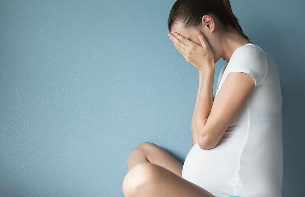 妊婦の女性が悲しんでいる写真