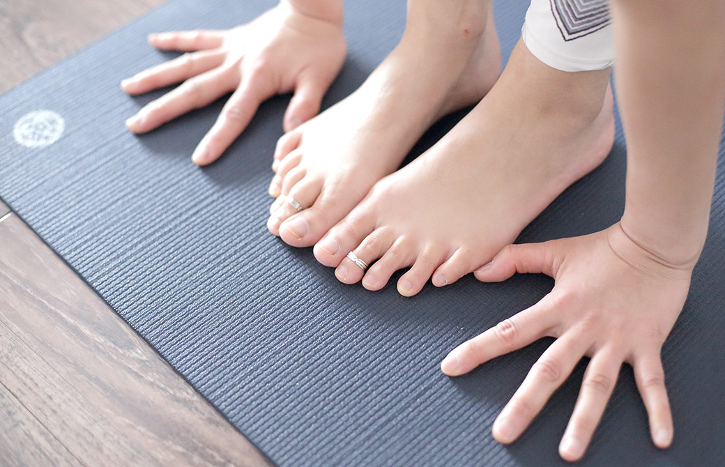 黒色のヨガマットの上で両手足をマットにつけている写真