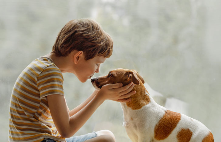 犬にキスをする少年