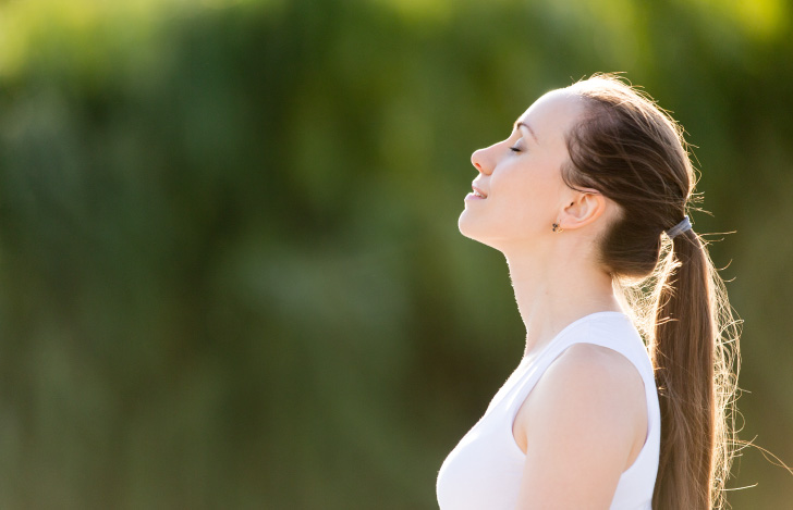 自然の中で深呼吸する女性の横顔