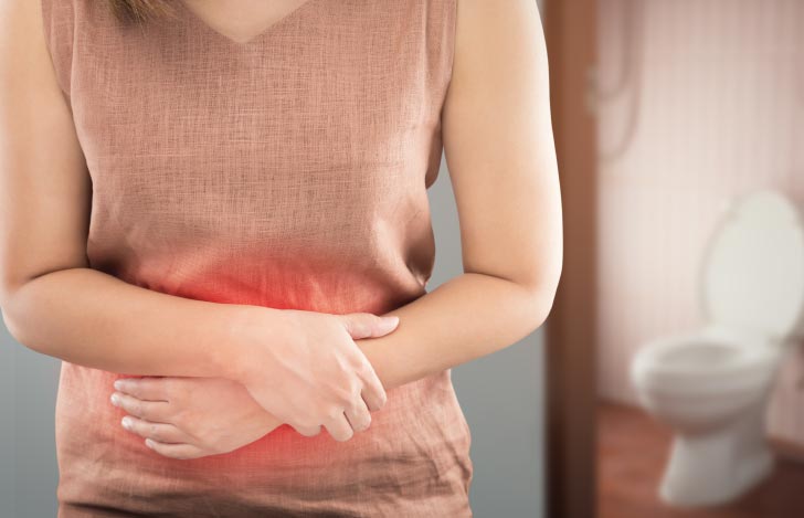 腹痛でお腹を抱える女性