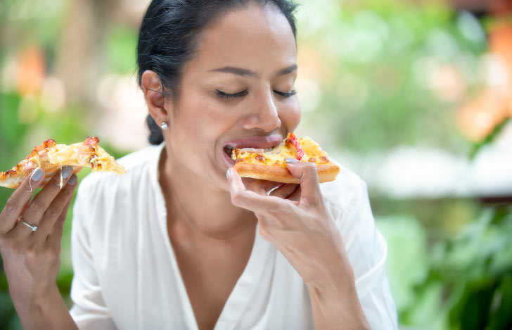 ピザを頬張る女性