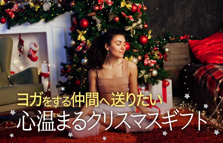 クリスマスツリーとプレゼントに囲まれて安楽座で座る女性