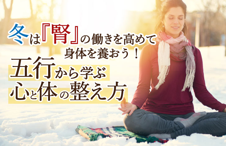 雪降る丘で瞑想する女性