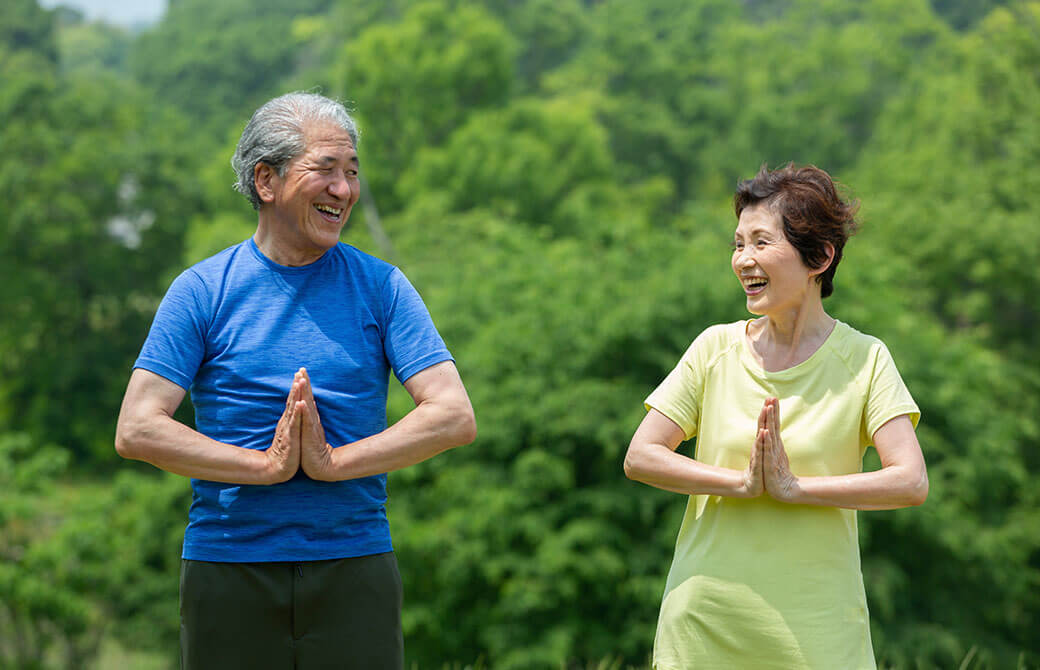 自宅でヨガをするシニア世代の男性と女性
