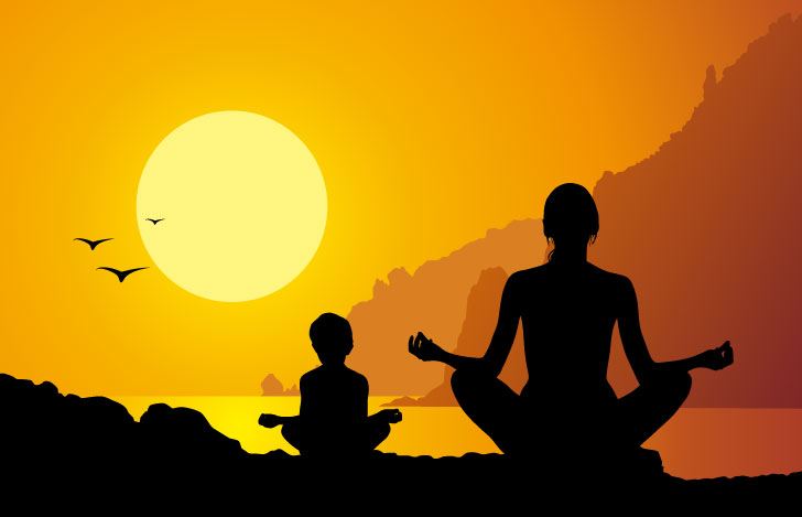 夕日に向かって安楽座で座る親子のシルエット