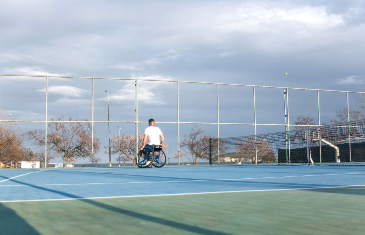 一人でテニスコートに佇む車椅子の選手