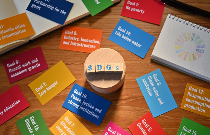 SDGsの文字が描かれた木のオブジェと17の目標が書かれた色とりどりのカード