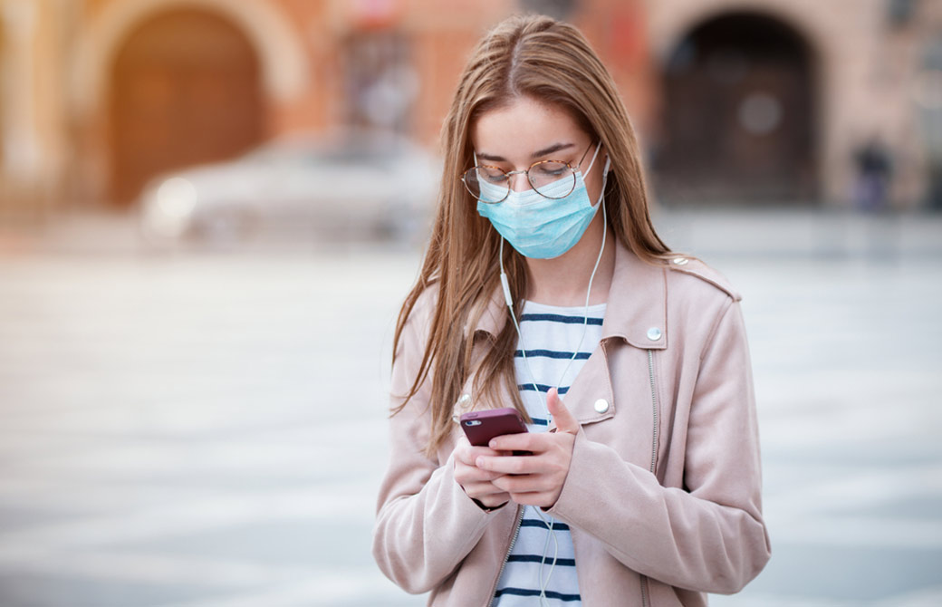 マスクをして下を向いて携帯