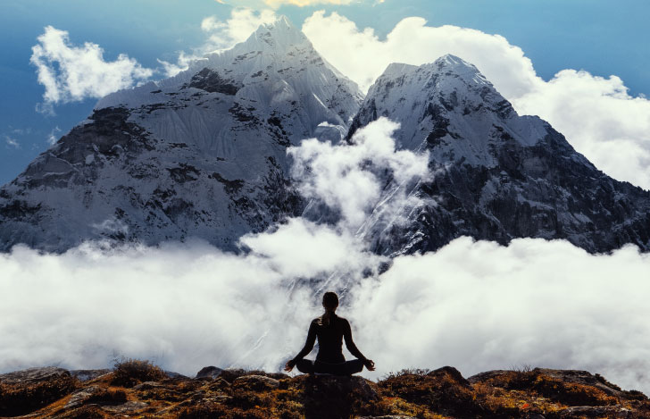 山々に向かって瞑想する人のシルエット