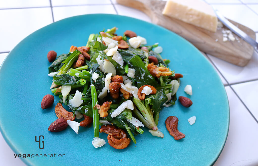 丸いターコイズのお皿に盛り付けたホウレン草とスパイシーナッツのホットサラダ