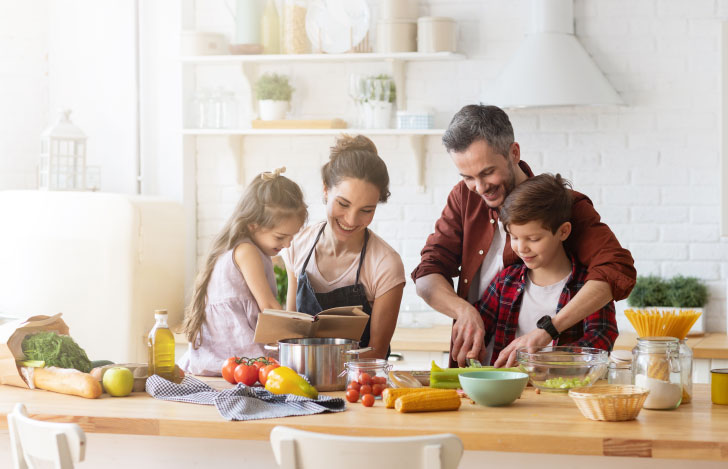 キッチンで健康的な食材を使って料理する家族