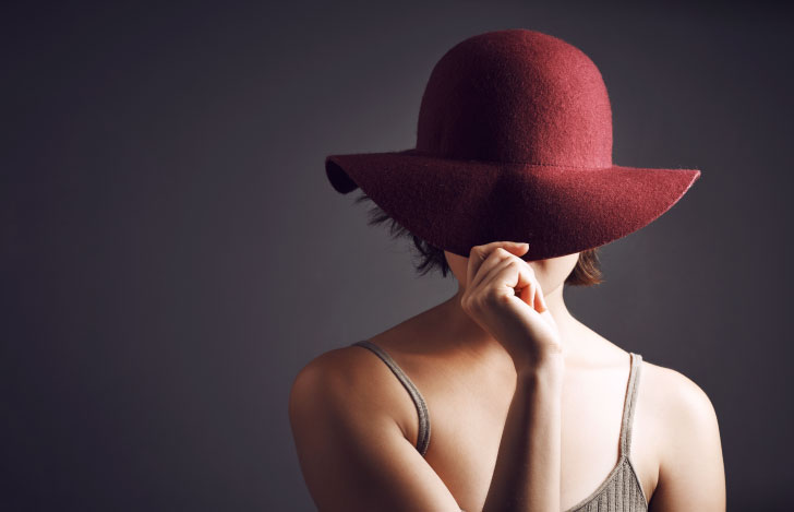 真紅の帽子を目深にかぶる女性