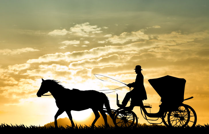 夕陽に照らされた馬車と御者と馬のシルエット