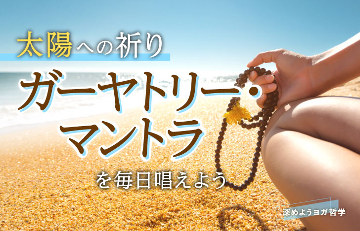 海辺で座り右手にマーラーを持つ女性の手元