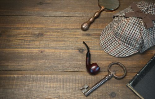 木の机に置かれた虫眼鏡・パイプ・帽子と鍵