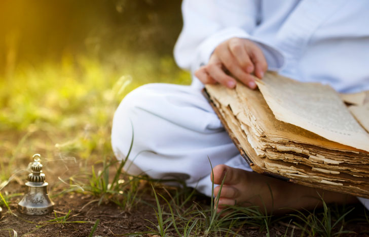 草原に座って古書を読む人の足元