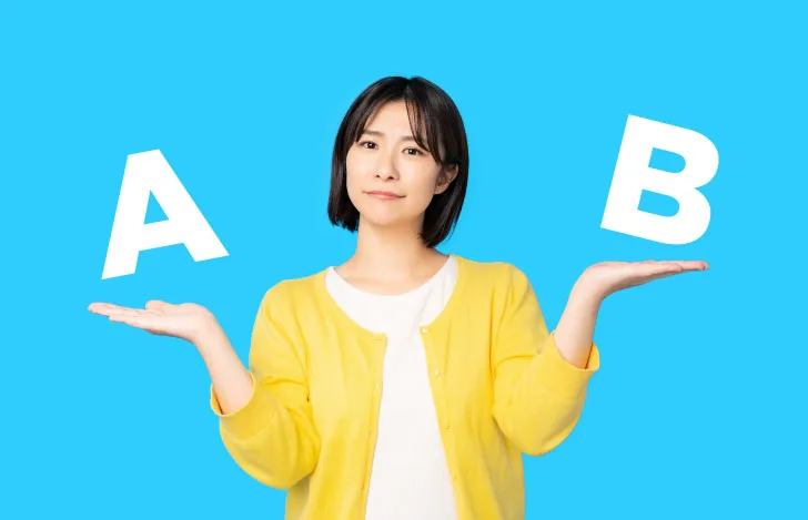 何かを悩んでいる表情で両手の平にあるAとBを比較している女性