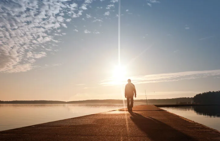 朝日に向かって歩く人の姿