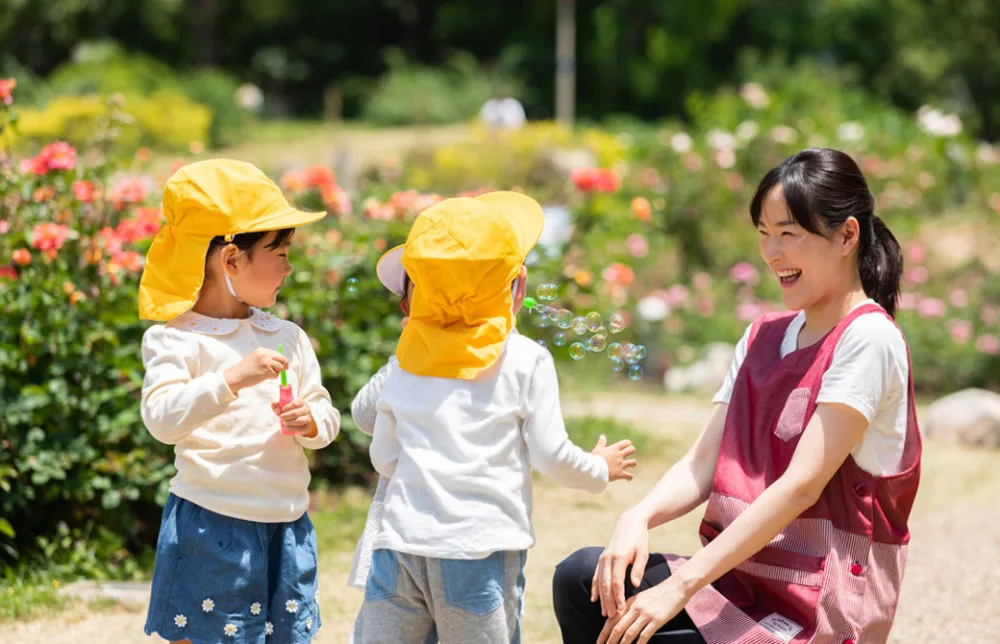 保育園で子どもと保育士が戯れている