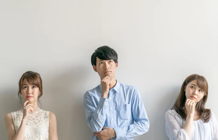 手を顎に当て考え事をする3人の男女