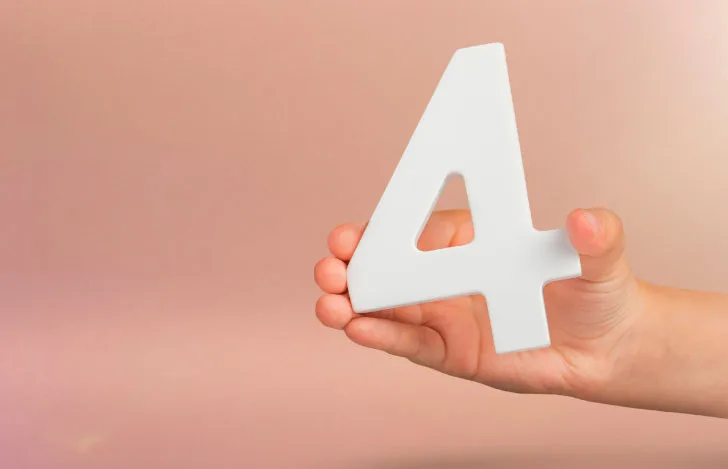 数字の4の形のオブジェを持つ人の手元