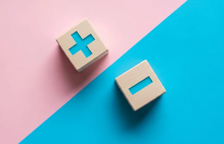 プラスとマイナスが彫られた木のオブジェ